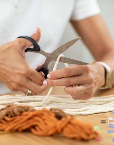 Artesano preparando material para elaborar joya artesanal en macramé con piedras naturales.