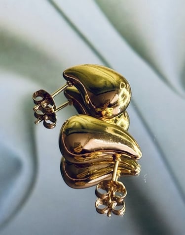 Aretes dorados chunky de Moreina Joyería con diseño minimalista y elegante, fotografiados sobre fondo suave.