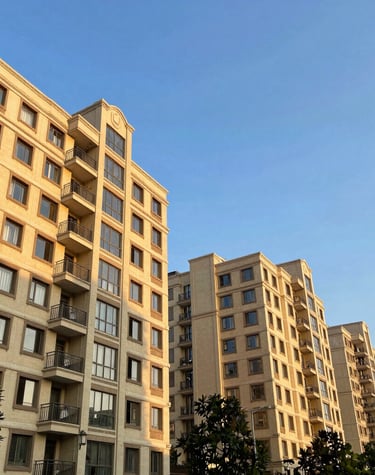 Elegant high-rise luxury apartment building at sunset with warm lighting.