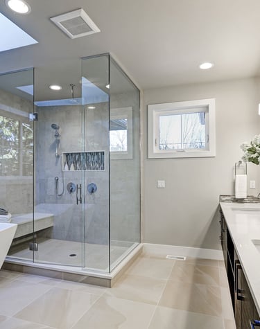 Cozy bathroom with warm lighting, a freestanding tub, and elegant tile work.