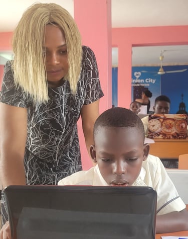 A female digital literacy instructor guiding a pupil on a computer project in class