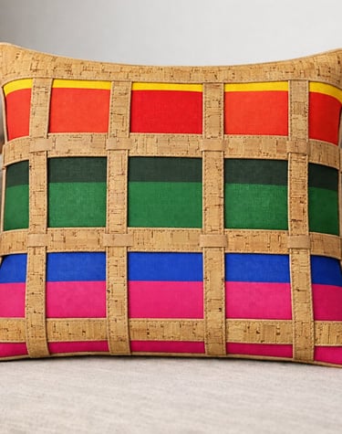 Handmade rainbow decorative pillow with unique cork lattice overlay on a modern beige sofa.