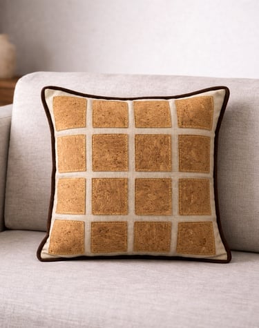 Handmade decorative throw pillow with cork patch grid design on a modern beige sofa.