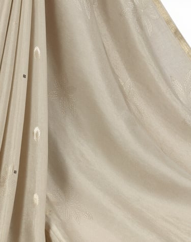 An office desk adorned with a folded katan saree and a gold-accented pen, capturing a blend of work and luxury.