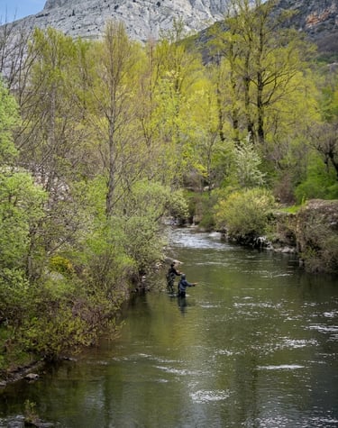 Pescador junto a su guía de pesca en un río de León, España