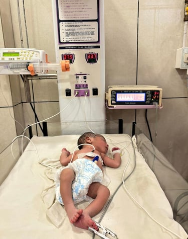 a baby in a hospital bed with a monitor and a monitor. Rini Hospital Dholpur