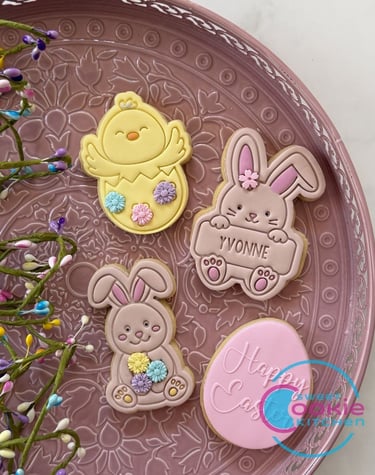 Custom Easter sugar cookies featuring a baby chick, bunnies, and a pink egg on a decorative tray.