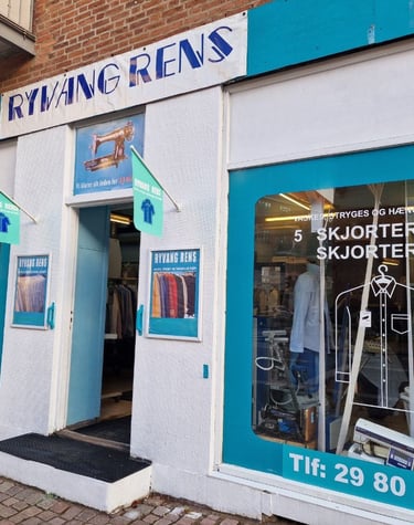 Facade af Ryang Rens butik med indgang og vinduer, der viser skilte og tekstilpleje-services.