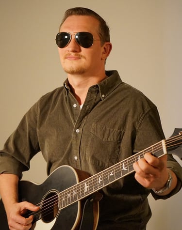 a man with sunglasses holding a guitar