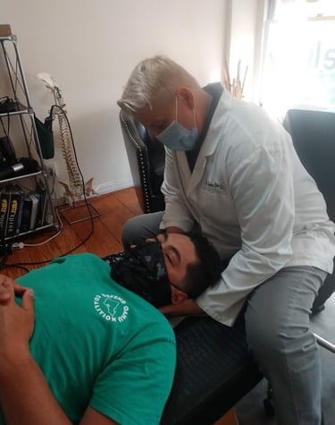 Dr. Lonna Denny performing a traditional neck adjustment to a patient.