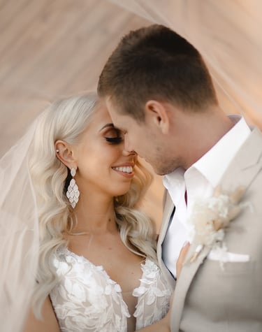 a bride and groom standing in front of a wooden wall