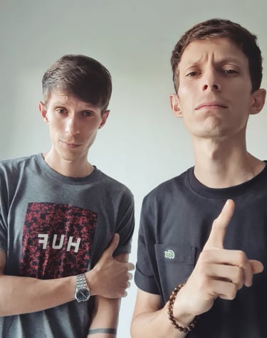 two men standing next to each other with their hands on their hipss