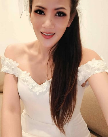 Ladyboy therapist wearing a frilly of the shoulder white dress