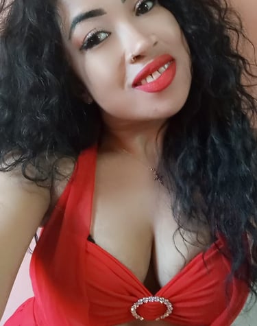 a smiling lady with long black hair wearing a red dress 