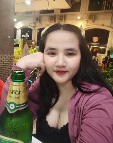 Lady therapist seated with fisted hand on cheek with a bottle of beer in front of her
