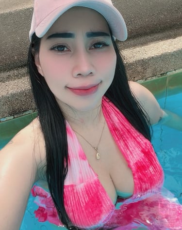 lady therapist in a swimming pool wearing pink bikini and baseball cap