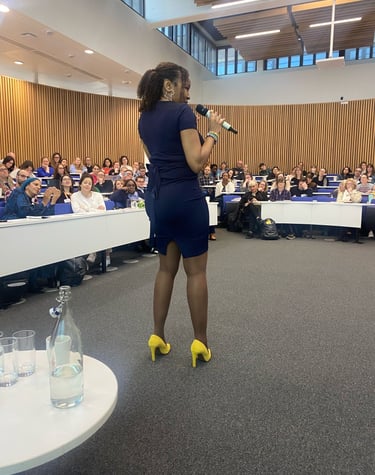 a woman in a blue dress standing in front of a crowd of people