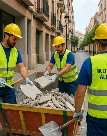 Tres trabajadores con chaleco reflectante desescombrando