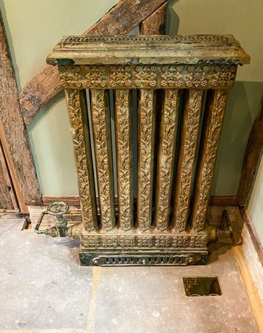 Vintage radiator with layers of paint applications and a faux painted pipe to match.