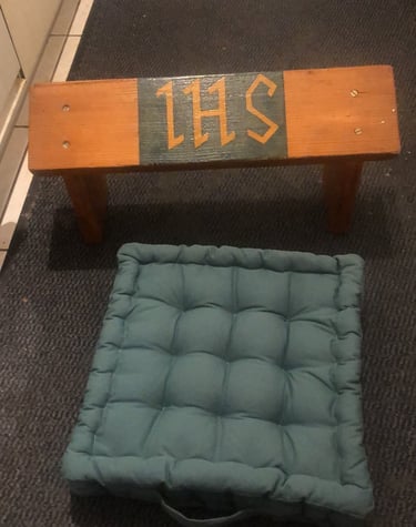 Sitting on a prayer stool while kneeling on the cushion, praying through rosary as long as it takes.