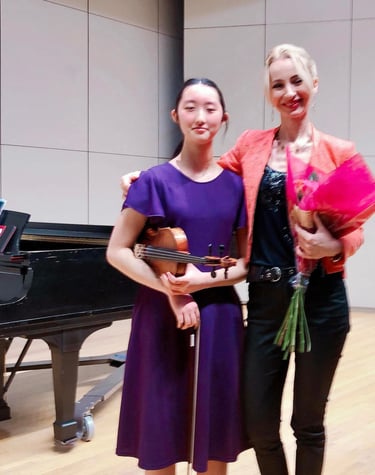 Violin student with her violin teacher after a successful recital