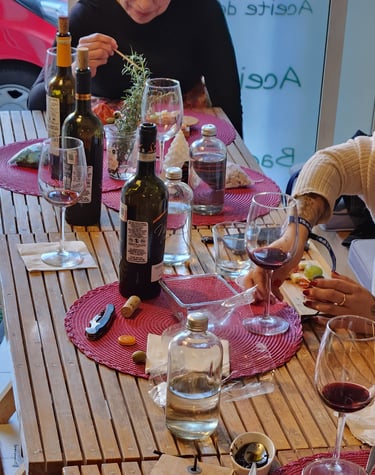 a group of people sitting at a table with wine glasses and wine bottles