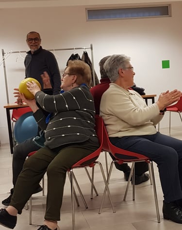 un grupo de personas mayores realizando unos ejercicios de movilidad asistido por un profesional