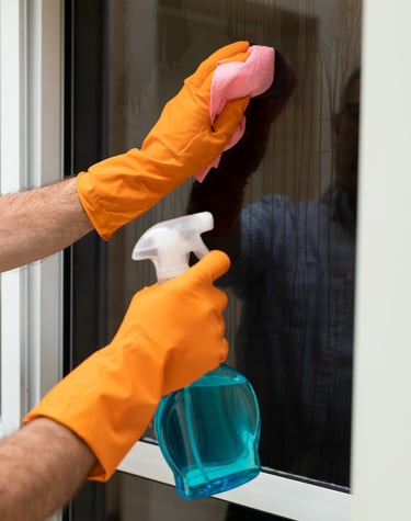 a man cleaning a window with a spray bottle