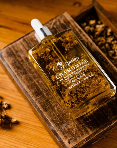 a bottle of oil with a wooden box and some nuts