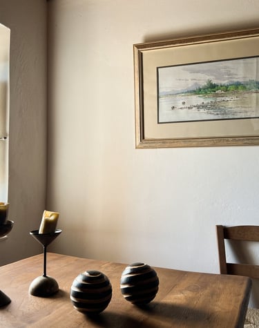 a table with three candles and a picture of a window