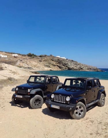 two jeeps parked on a sandy beach