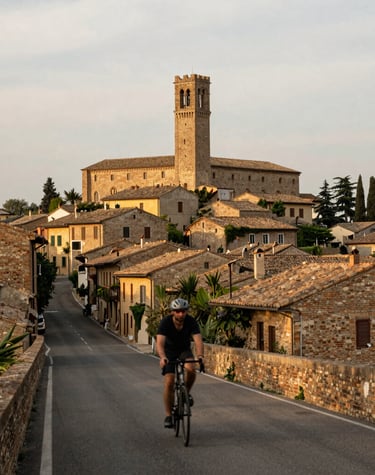 Historic village streets framed by colorful houses and cyclists passing through.