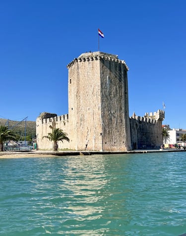Sea level view of Kamerlengo Fortress and UNESCO protected city of Trogir during a private boat tour from Split, Croatia