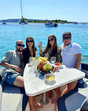 Group celebrating a birthday at Blue Lagoon on a boat, sitting around a table with fruit and drinks on private tour in Split