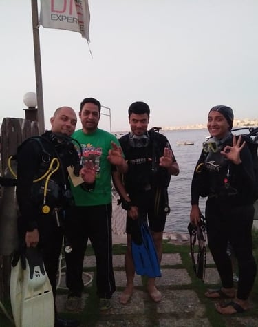 a group of Divers standing around Captain Essam