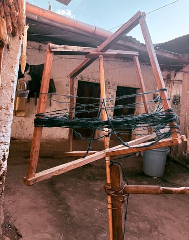  Bobinadora de hilo de madera tradicional que hila hilo de lana oscura en un entorno de patio