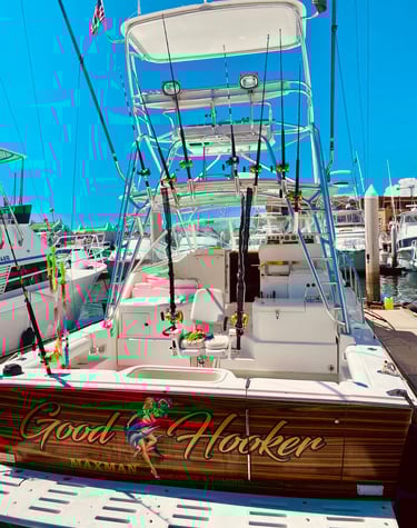 Charter fishing boat in a marina with fishing rods, a fighting chair, and custom woodwork.