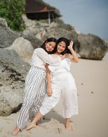 Two daughters embracing each other on the beach at Karma Kandara Bali  