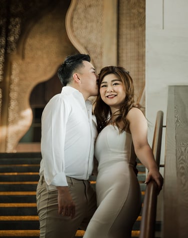 Elegant couple portrait on the grand staircase during a romantic prewedding session at Apurva Kempinski Bali