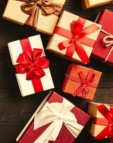 varios regalos sobre una mesa con moño rojo