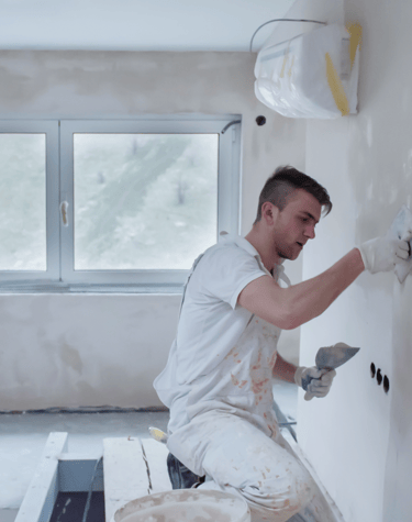 Imagen de pintor haciendo reparaciones en un pared.