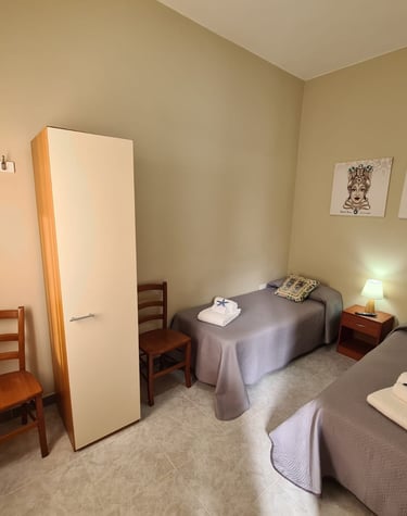 a bedroom with two beds and a chair