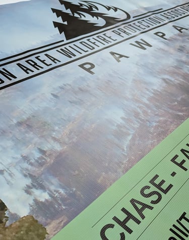 A large printed banner featuring a colorful design and bold text, hanging on a wall at an event, pro