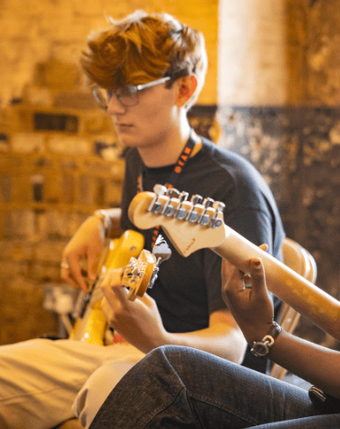 An image of Jamie Walker playing electric bass with NYJO