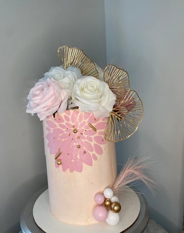 a cake with a pink and gold flower arrangement