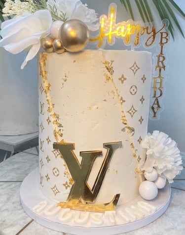 a cake with a gold foil lettered on top of a table