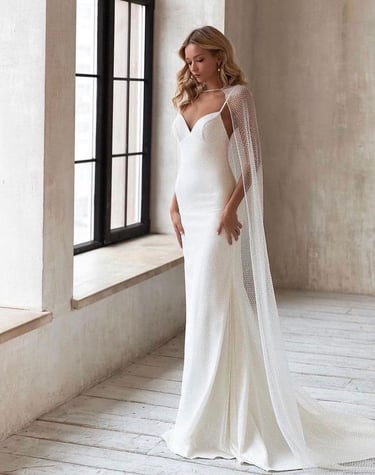 belle mariée portant une robe fluide avec une cape