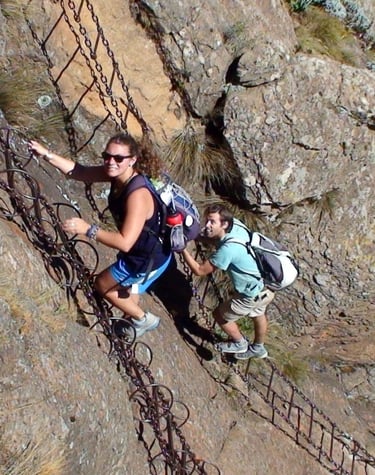 two backpackers climbing a chain ladder in South Africa