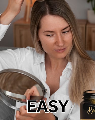 A LADY APPLYING DRY SHAMPOO POWDER TO HER HAIR 