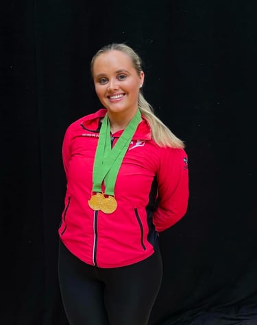 a woman in a red jacket and a medal. just received 2 gold medals
